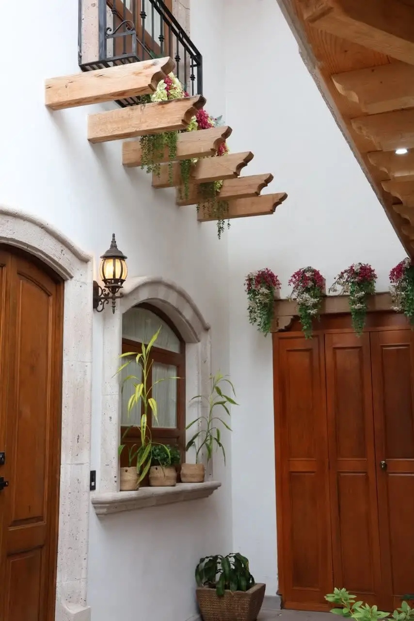 Escalinata de madera colgante con buganvilias en el pasillo interior