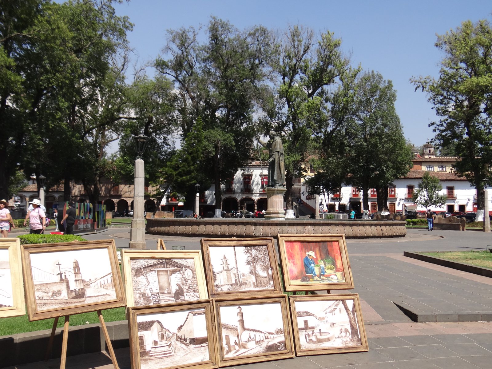 Plaza con estatua y pinturas artesanales