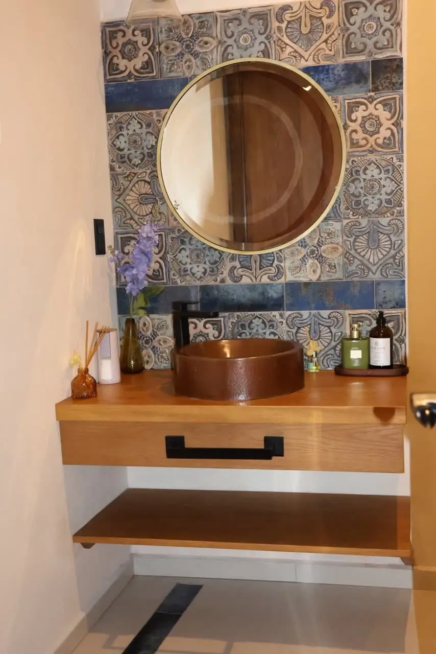 Baño con lavabo de cobre y mosaico talavera azul