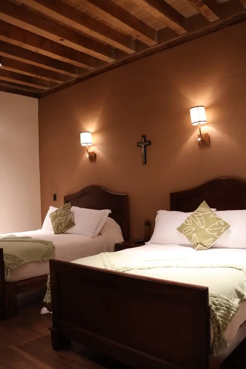 Recámara con vigas de madera y ropa de cama en tonos verdes