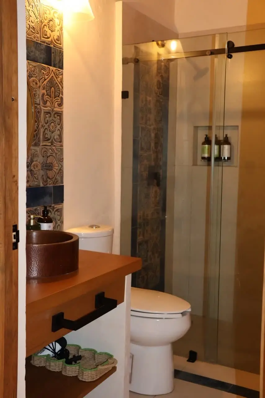 Baño con regadera de cristal y mosaico talavera