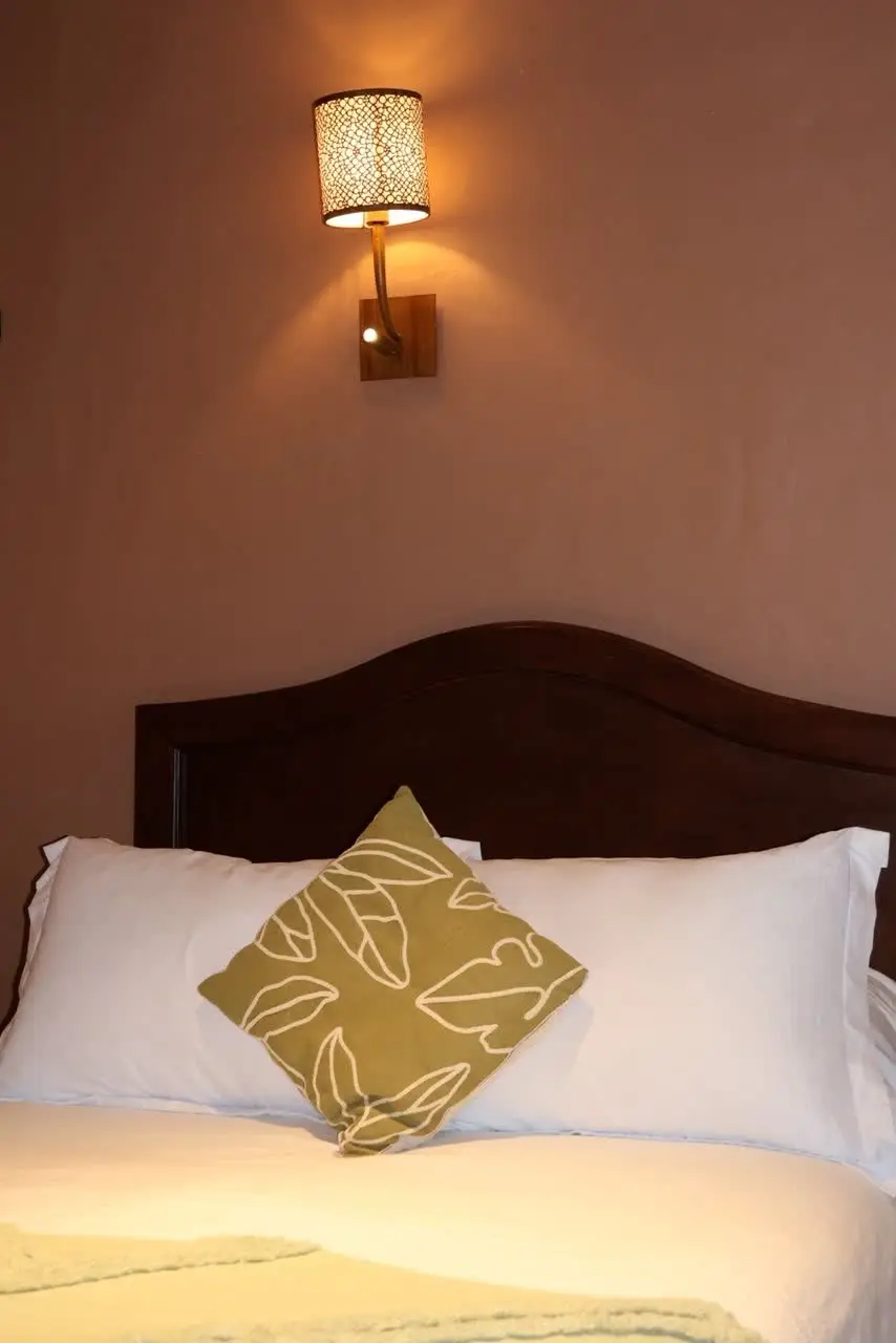 Detalle de cojín bordado junto a la lámpara de noche