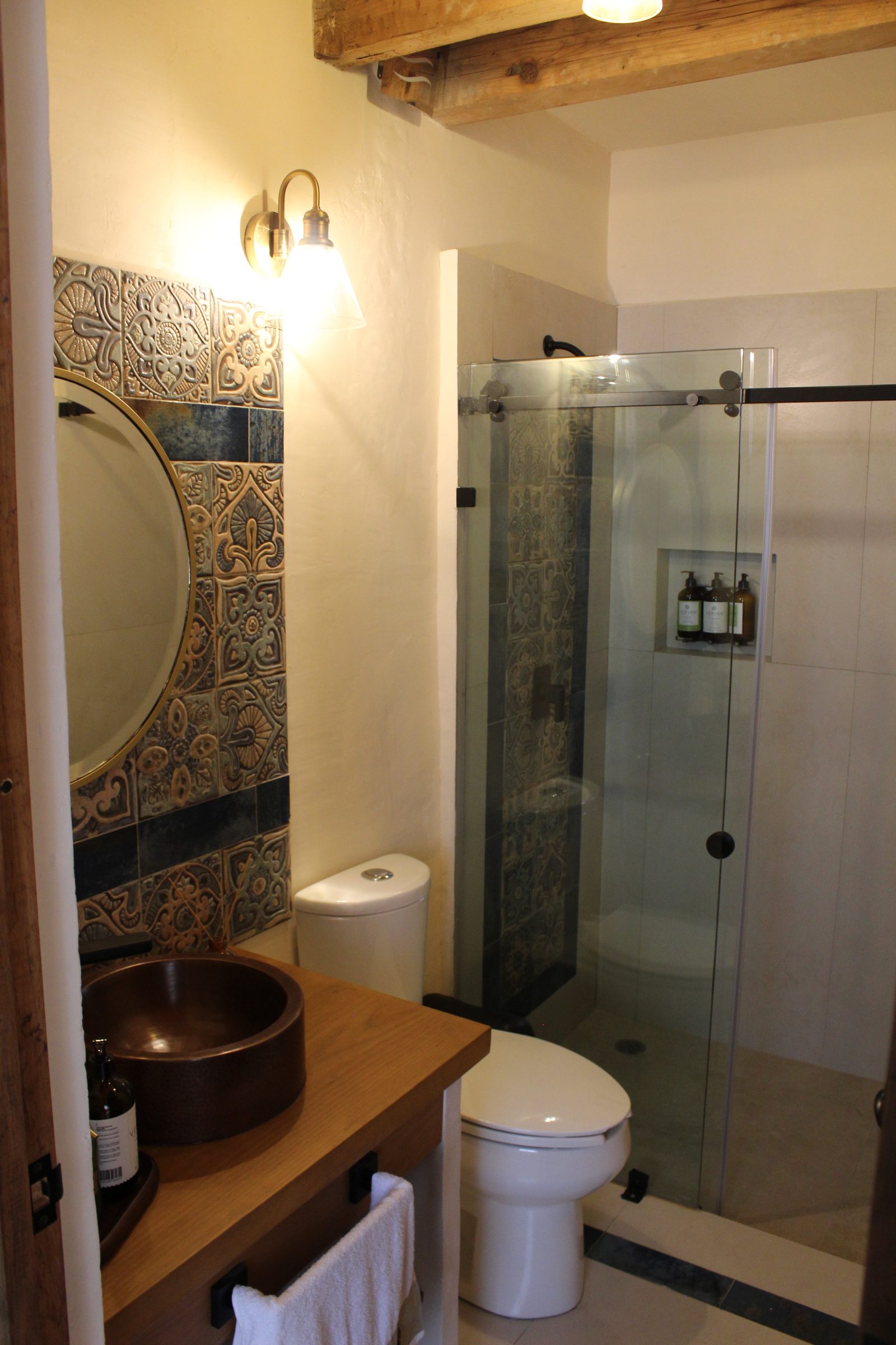 Baño con regadera de cristal y talavera azul