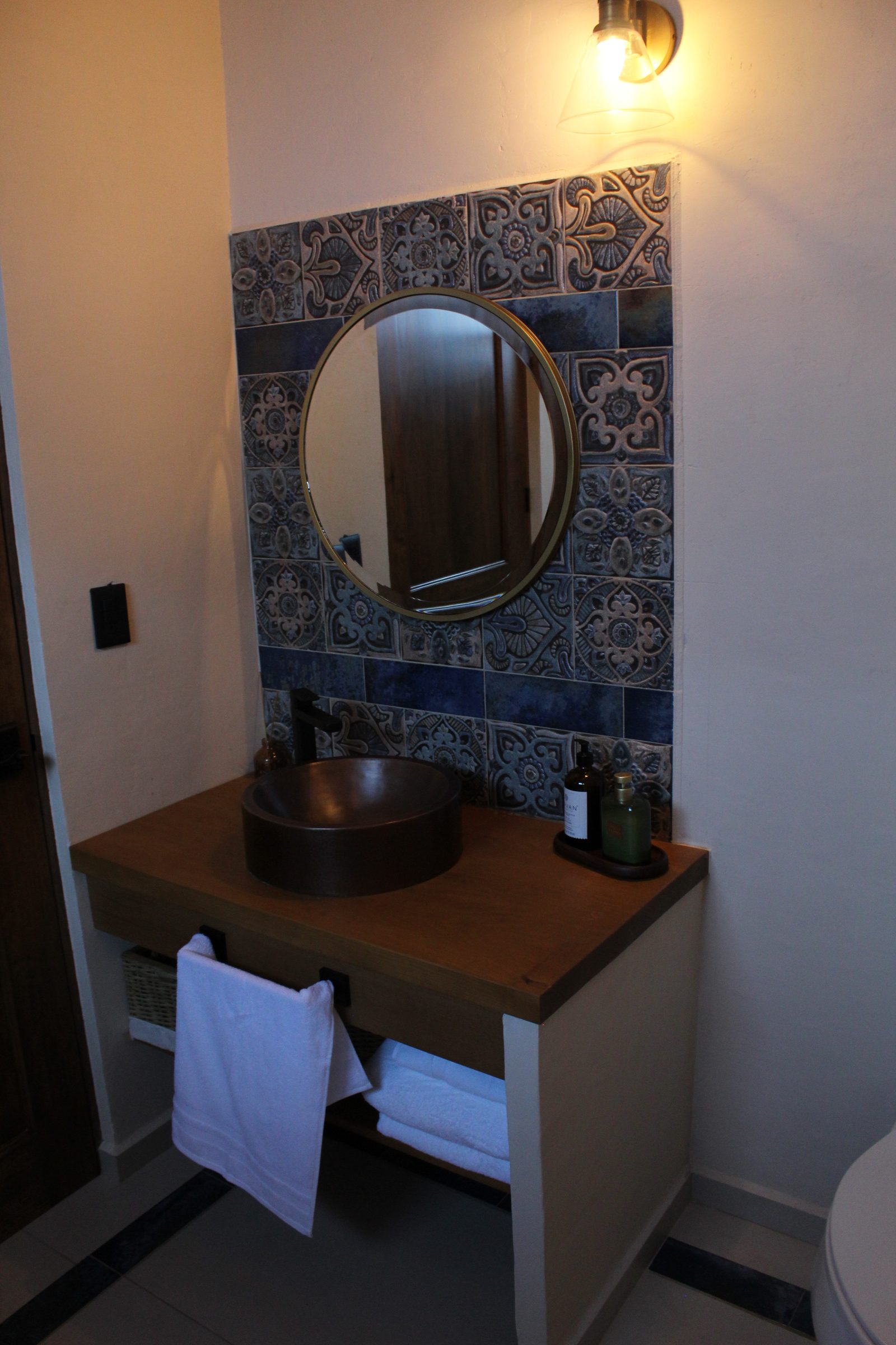 Baño con lavabo de cobre y mosaico azul