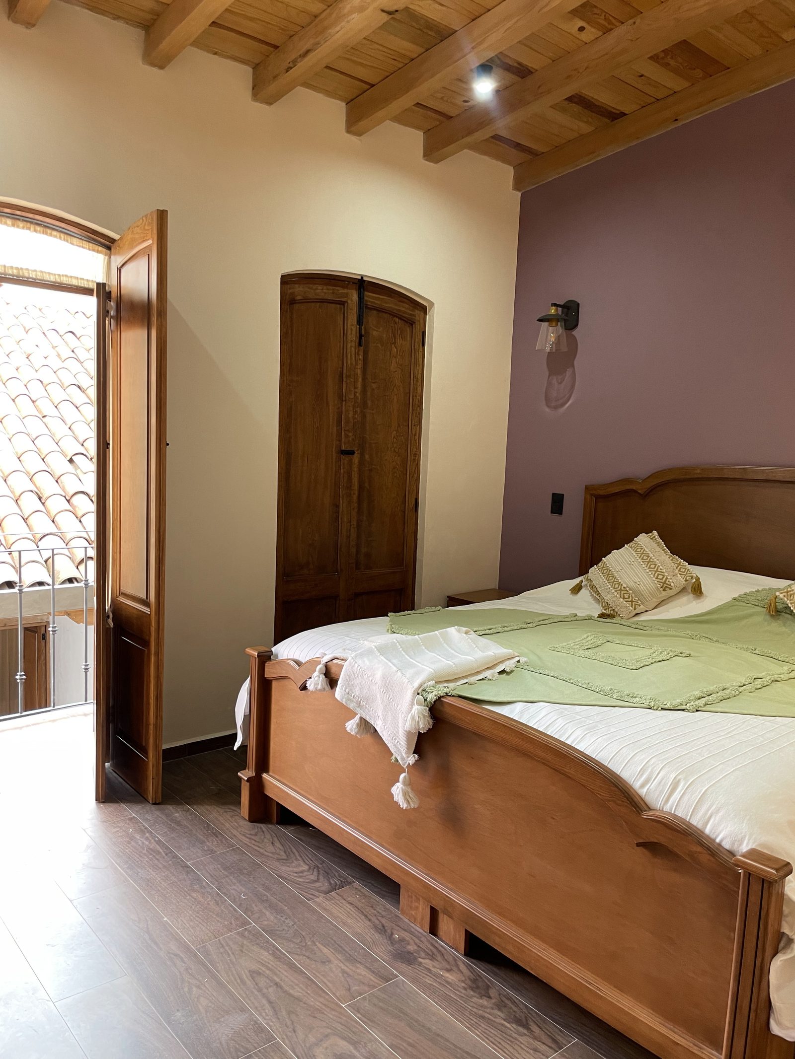 Puerta abierta al balcón privado con vista a tejados