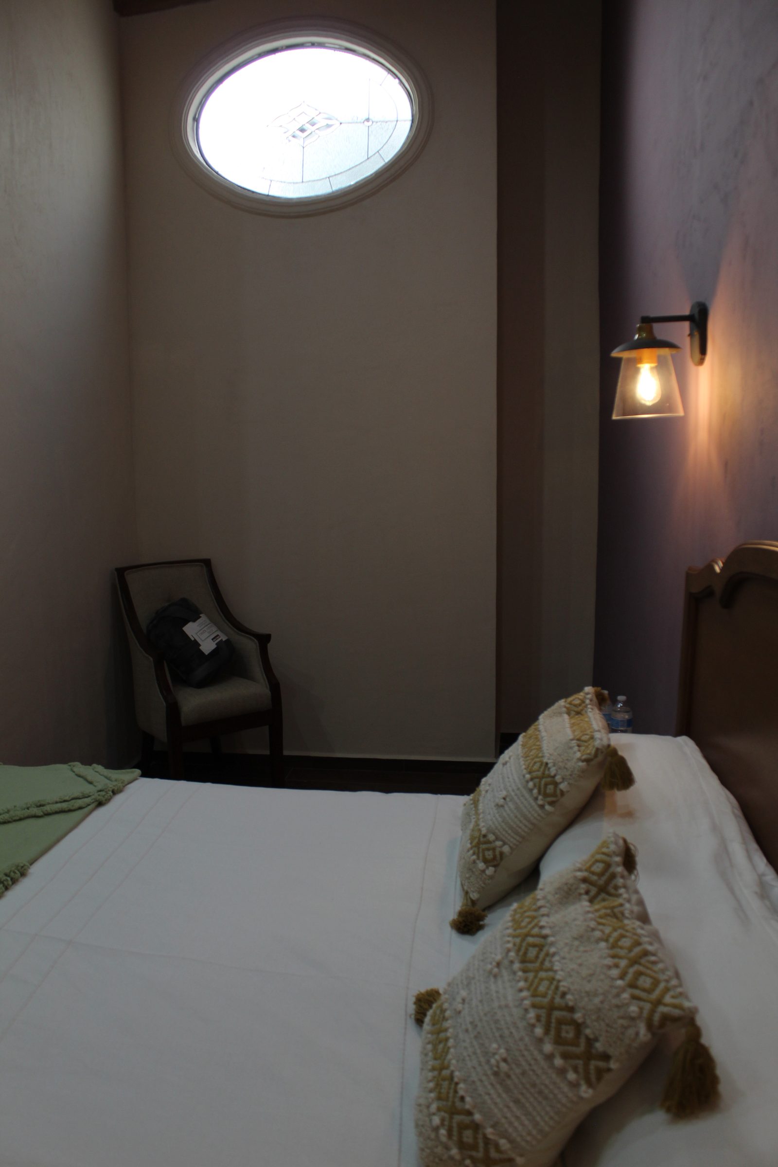 Recámara con cama Queen y ventana ovalada