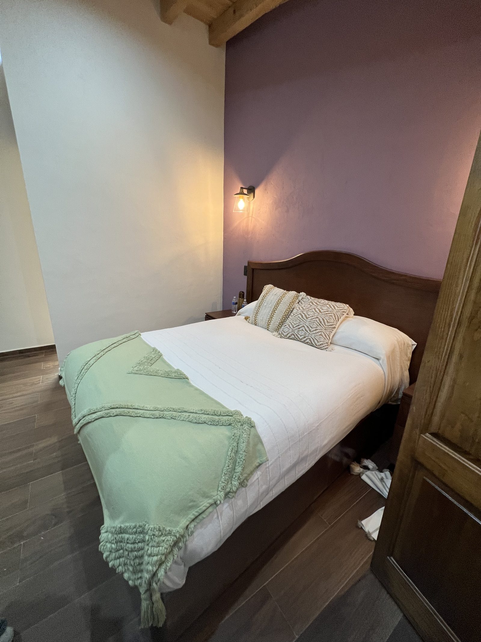 Cabecera de cama con manta verde y luz natural