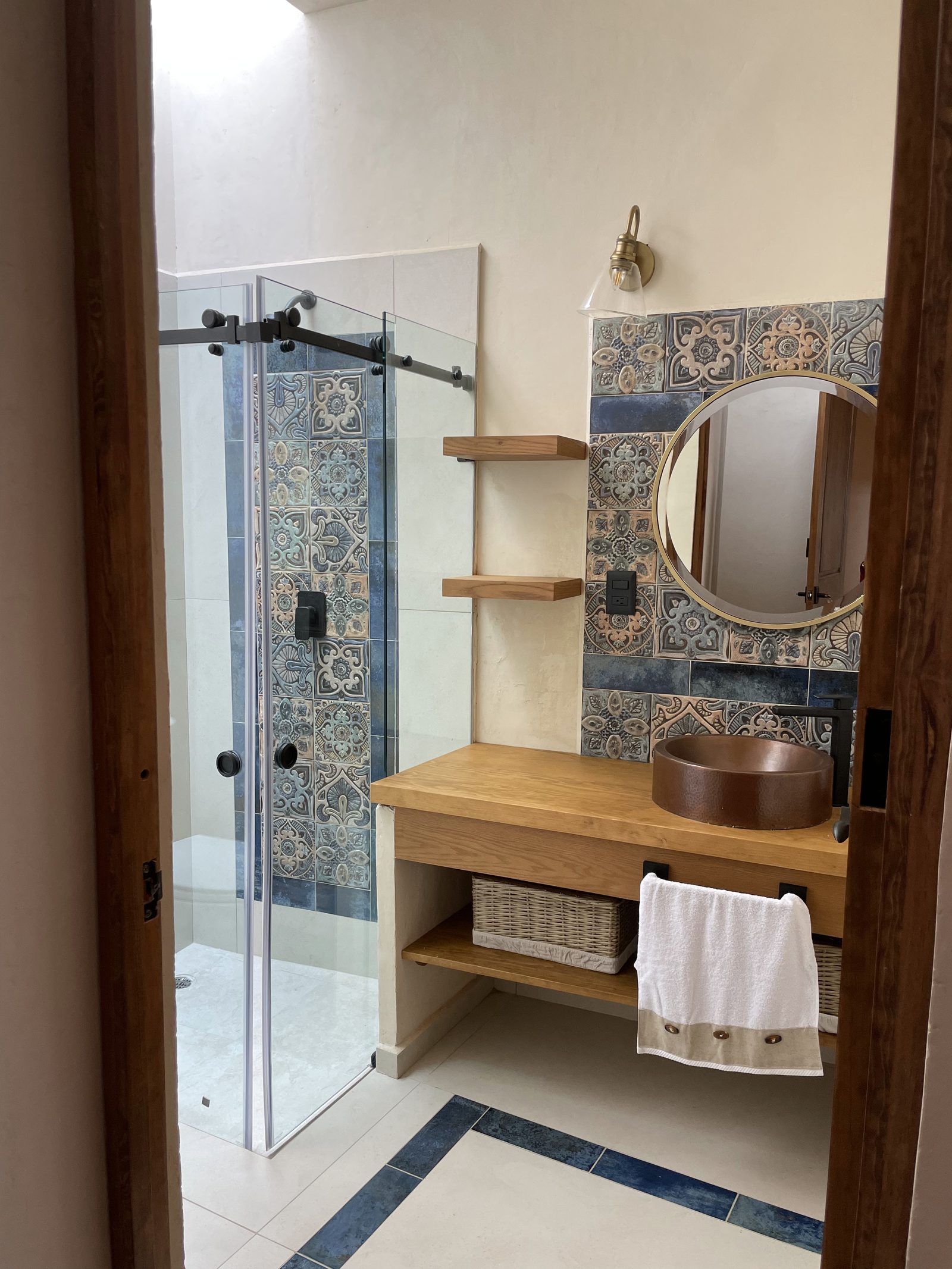 Baño con regadera de cristal y mosaico talavera