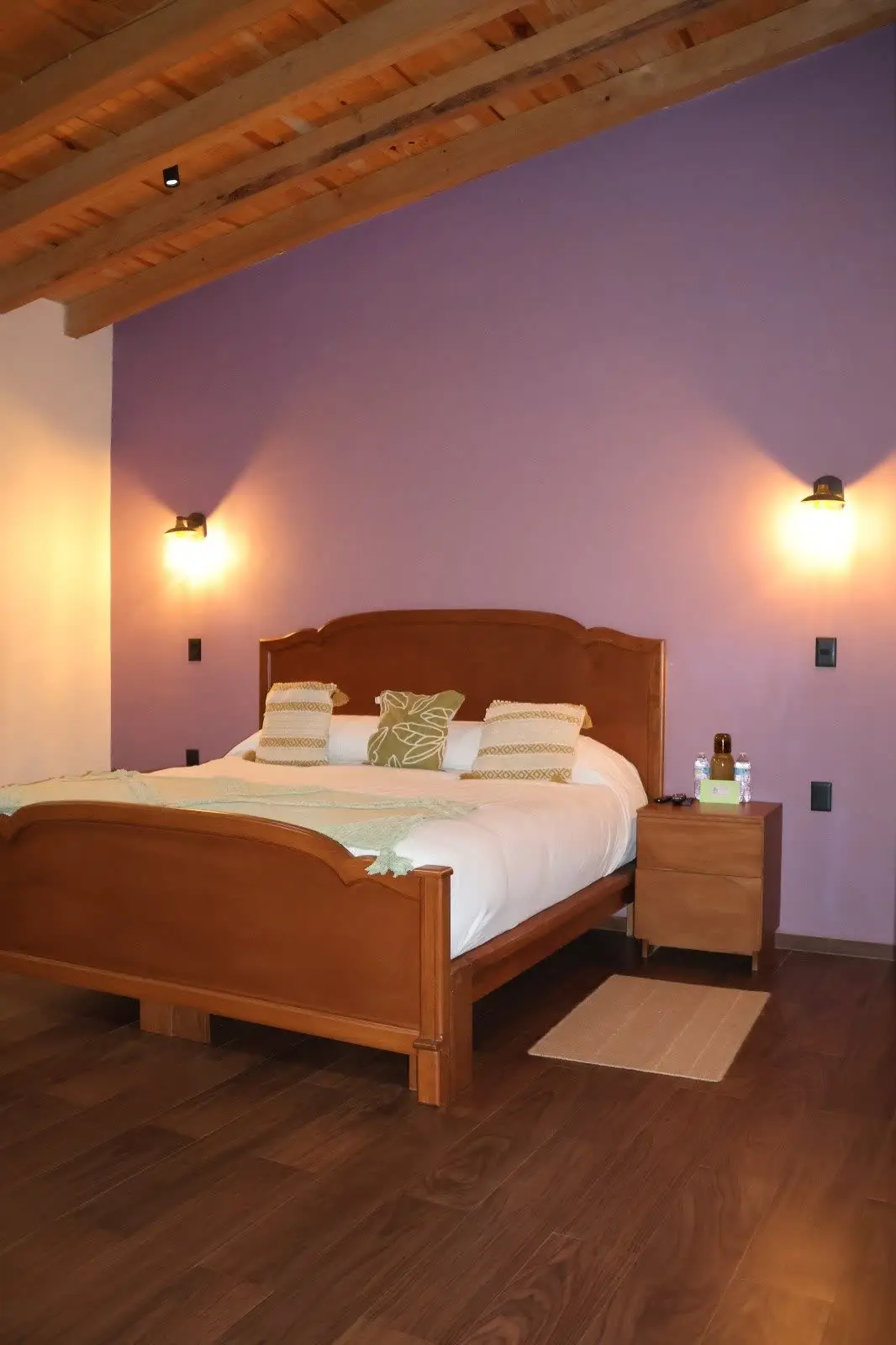 Recámara King con pared malva y luz cálida