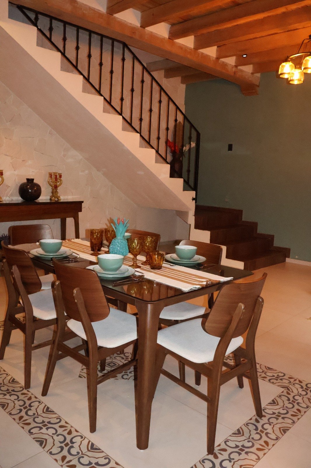 Comedor con escalera de madera y vigas vistas