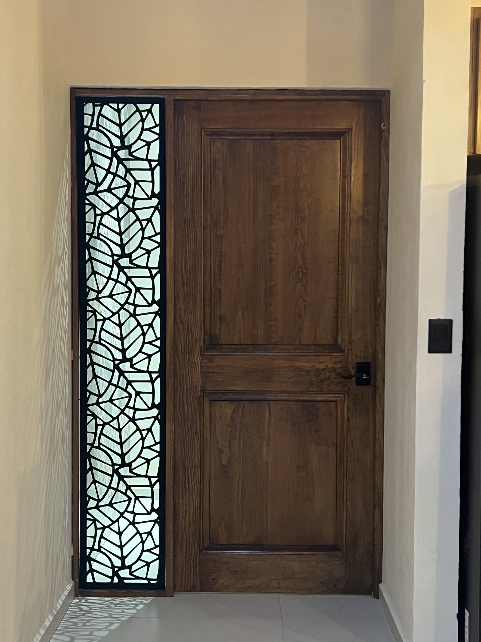 Puerta tallada con vitral de hojas